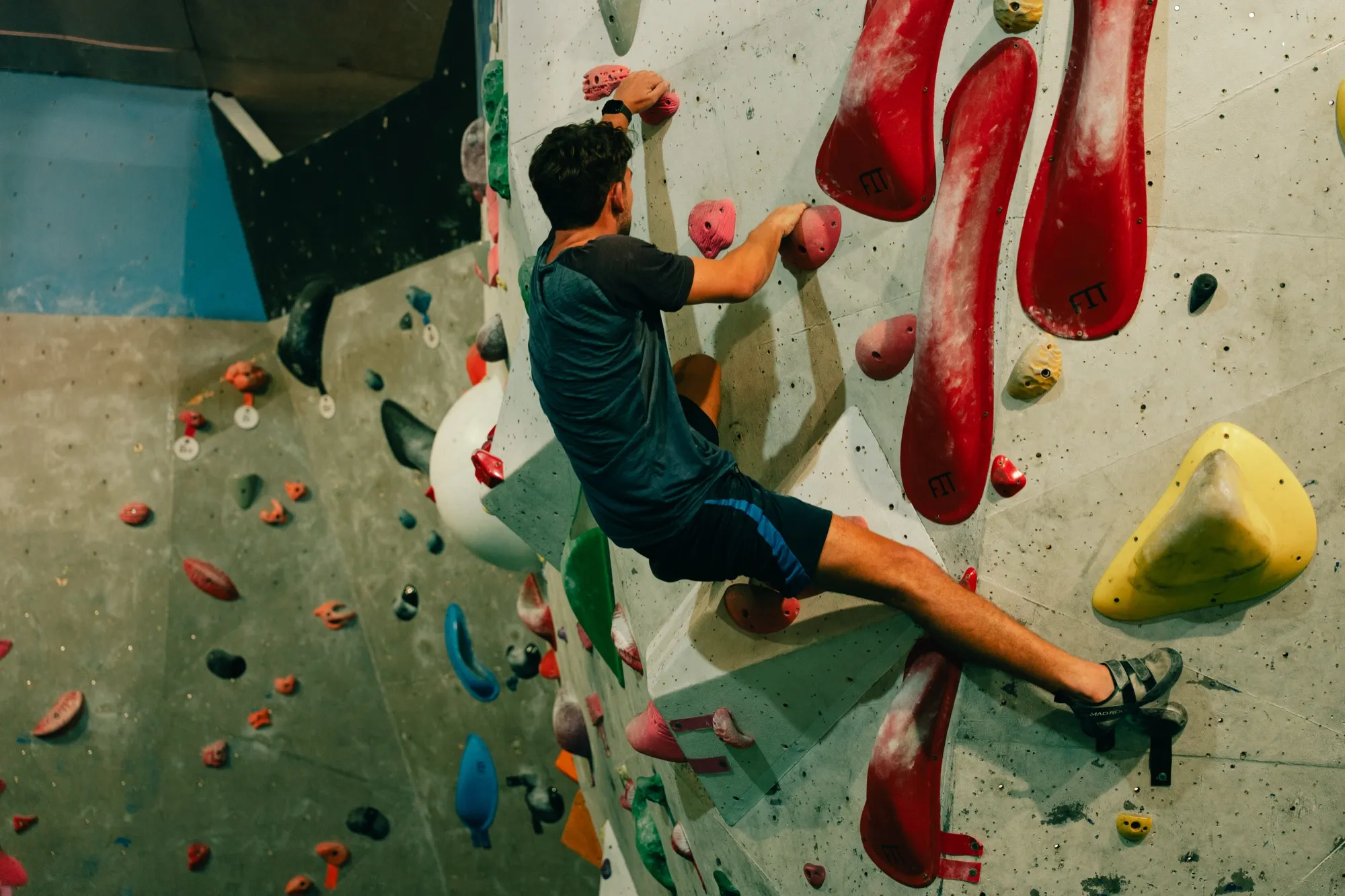 Grimpeur sur le mur aux grandes prises rouges